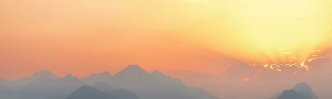 bright sunset or sunrise sky with misty mountains photo