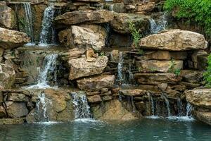 landscape design, a dam with a cascade of waterfalls in the form of natural rocks photo