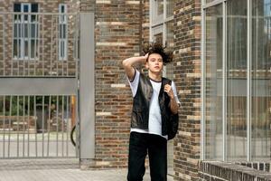 young man on the street against the backdrop of city buildings photo