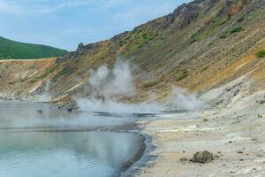 hot mineralized lake with thermal spring and smoking fumaroles in the caldera of the Golovnin volcano on the island of Kunashir photo