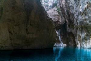 clear blue water in a deep canyon with sheer rock walls photo