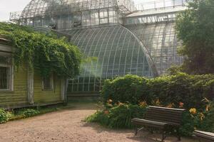 esquina de un antiguo botánico jardín con un enorme Clásico invernadero en el antecedentes foto