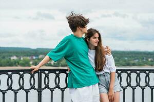 Pareja de joven personas abrazando en el terraplén encima el río foto