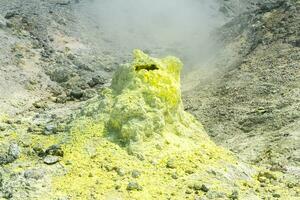 cone of sulfur deposits around a fumarole in a solfataric field photo