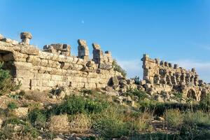 ruins of ancient city walls against the backdrop of the sky with moon in Side, Turkey photo