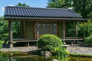 té casa detrás estanque en japonés jardín foto