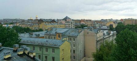 view of the roofs and church domes in the historical center of St. Petersburg during the rain photo