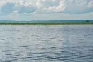 natural landscape, vast shallow lake with reed banks on a cloudy day photo