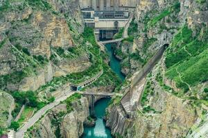 view of the lower part of the arch dam with a spillway in the canyon photo