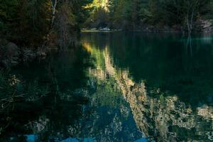 otoño montaña paisaje con sombreado lago en el garganta foto