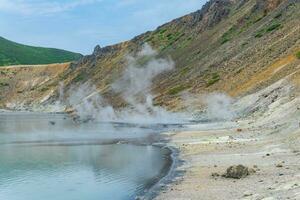 hot mineralized lake with thermal spring and smoking fumaroles in the caldera of the Golovnin volcano on the island of Kunashir photo