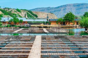 fish farm with commercial fishing and a fish restaurant on a river in a mountain valley photo