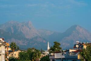 landscape with distant blue mountains behind city rooftops, Kemer, Antalya, Turkey photo