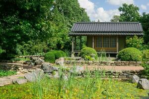 té casa cerca estanque en japonés jardín foto