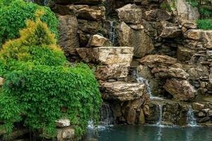landscape design, a dam with a cascade of waterfalls in the form of natural rocks photo