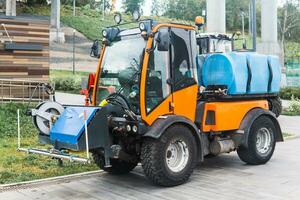 small tank truck for cleaning paths and watering plants in the city park photo