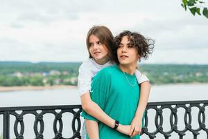 couple of young people hugging against a blurred river landscape photo