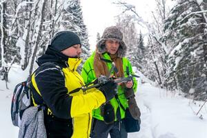 dos hombres en el invierno bosque lanzamiento un quadcopter foto