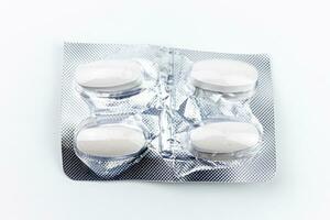 Close up of white pills in blister pack isolated on white background. photo