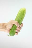 Cucumber in hand isolated on white background with clipping path. photo