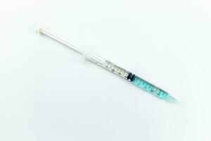 syringe with blue liquid inside on white background. Isolated photo