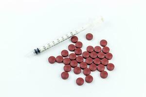 Syringe and red pills isolated on white background with clipping path. photo