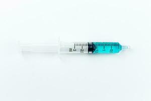 Medical syringe with blue liquid inside on a white background. Isolated with clipping path. photo