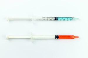 Medical syringe with red and blue liquid isolated on white background. photo