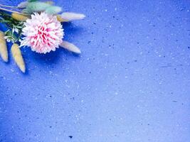 Flowers on blue background. Flat lay, top view, copy space photo