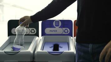 Close-up of man throwing garbage into sorting bins. Media. Man throws garbage into colored bins for sorting. Sorting garbage helps in recycling and supports ecology of nature photo