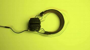 Headphones on colored background with lines. Animation. New headphones lie on colored background with animated lines. Animated lines follow shape of headphones photo