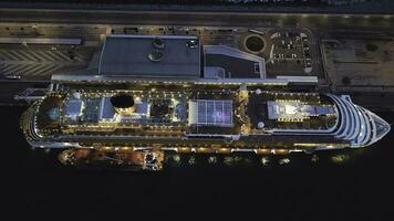 Top aerial view of an open deck of the cruise ship at the harbor. Stock. Romantic landscape of a luxury cruise liner with basketball field and swimming pool. photo