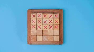 Wooden game board tic-tac-toe. Turning of the letters X-O and middle one different from each other on blue background. video