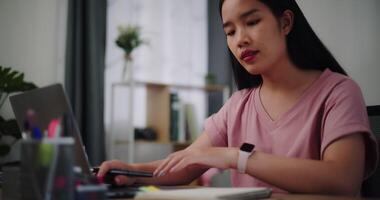 Footage of Young woman typing work with laptop on a desk in home office. video