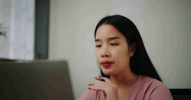 beeldmateriaal dichtbij omhoog van jong vrouw aan het doen video conferentie Aan een laptop Aan een bureau in huis kantoor