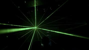 club juventud fiesta. acortar. verde láser vigas en el iluminar desde el fondo siguiente a el DJ y bailando gente. foto