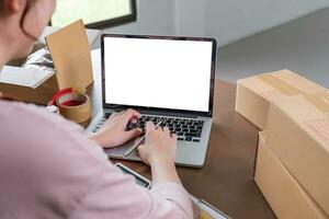 Entrepreneur using calculator with pencil in her hand, calculating financial expense at home office,online market packing box delivery,Startup successful small business owner, SME, concept photo