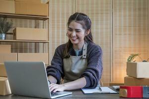 PYME emprendedora de pequeñas empresas, mujer asiática empacando tela en caja. retrato joven propietario de una pequeña empresa asiática oficina en casa, entrega de marketing de venta en línea, concepto de telemarketing de comercio electrónico sme foto