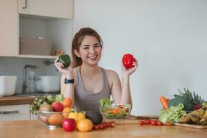 Sporty young woman is preparing healthy food on light kitchen. healthy food concept. photo