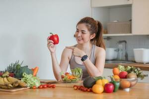 Sporty young woman is preparing healthy food on light kitchen. healthy food concept. photo