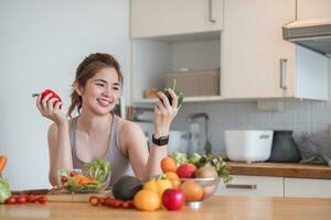 Sporty young woman is preparing healthy food on light kitchen. healthy food concept. photo