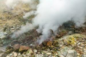 Exciting view of volcanic landscape, erupting fumarole, aggressive hot spring, gas-steam activity in crater of active volcano. Beautiful mountain landscape, travel destinations for active vacation. photo