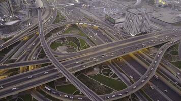 Aerial top view of highway junction with traffic in Dubai, UAE, at sunset. Famous Sheikh Zayed road in Dubai downtown. Transportation and driving concept view from rooftop photo