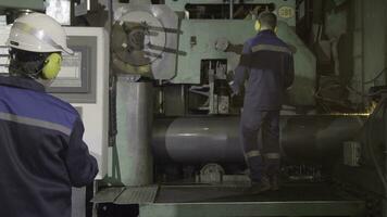 Making metal pipes and tubes in an engineering factory. Worker on the pipe metallurgical plant. Cooling pipe on the machine photo