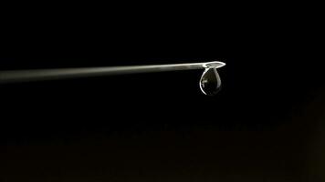 Close up Syringe needle medicine with liquid medicine drop on a black background. Close-up of syringe with drop. Selective focus on nib photo