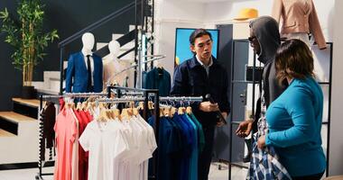 Shoplifter trying to stole trendy merchandise from shopping centre, being caught by asian security guard. African american couple arguing with bodygurad, trying to escape accusation in clothing store photo