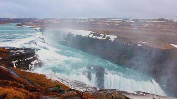 Gullfoss waterfall in reykjavik iceland, spectacular nordic landscape with snow and cold water falling off cliff. River scenery on top of the hill, icelandic nature with cascade. Handheld shot. photo