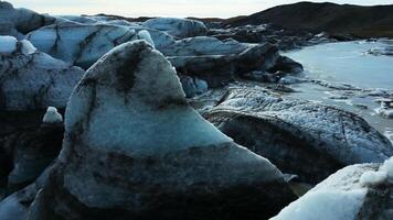Drone shot of vatnajokull glacier mass, beautiful blue ice blocks with crevasses and icebergs near snowy mountains. Massive icy rocks with frost floating on lake. Slow motion. photo