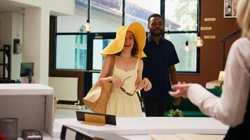 Receptionist providing luxury service to travellers checking in at exotic summer resort, travelling on honeymoon. Tourists with tropical clothes registering at front desk in lobby. photo