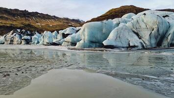 Huge vatnajokull glacier ice chain, fantastic blue rocks forming glacier lagoon near frozen lake in iceland. Spectacular nordic icebergs with crevasse and glacial ice caves. photo